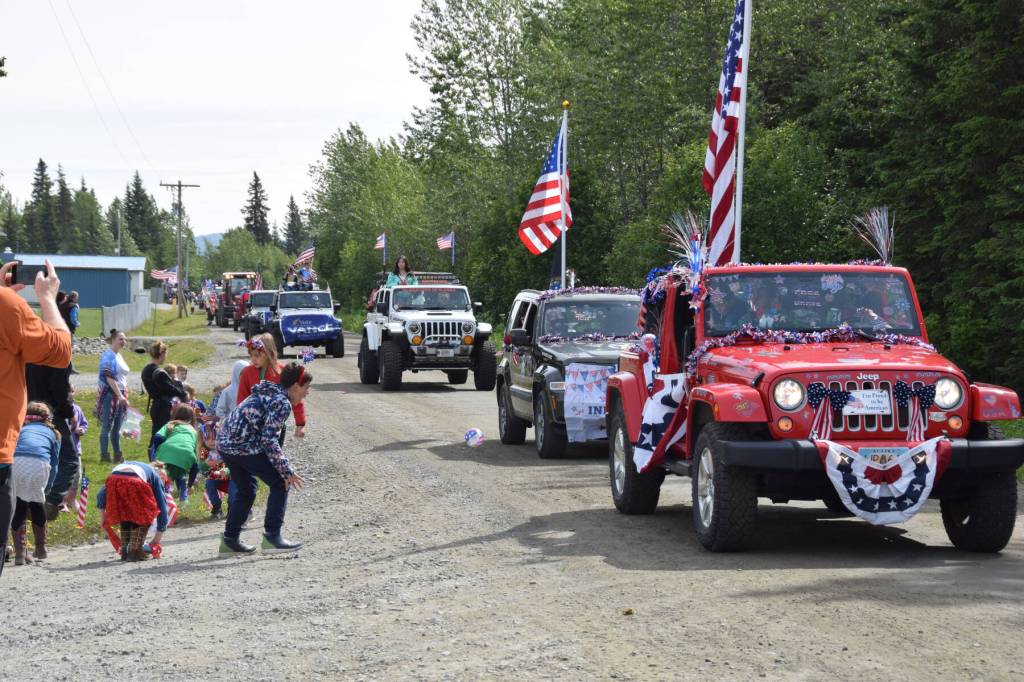 Participants in the Anchor Point Fourth of July parade toss candy out to kids and spectators on Thursday, July 4, 2024, in Anchor Point, Alaska. (Delcenia Cosman/Homer News)