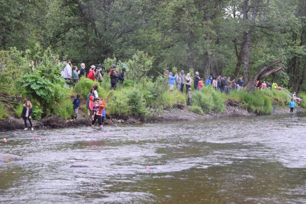 Spectators gather on the riverbank near the finish line during the third annual Anchor River Duck Races on Saturday, July 6, 2024, in Anchor Point, Alaska. (Delcenia Cosman/Homer News)