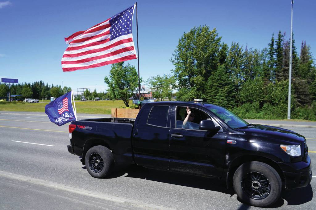 Jake Dye/Peninsula Clarion
A parade of cars and trucks flying flags in support of former President Donald Trump proceed down the Kenai Spur Highway in Kenai on Sunday.
