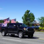 A parade of cars and trucks flying flags in support of former President Donald Trump proceed down the Kenai Spur Highway in Kenai, Alaska, on Sunday, July 14, 2024. (Jake Dye/Peninsula Clarion)