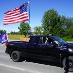 A parade of cars and trucks flying flags in support of former President Donald Trump proceed down the Kenai Spur Highway in Kenai, Alaska, on Sunday, July 14, 2024. (Jake Dye/Peninsula Clarion)