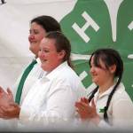 Levi Rankin, Ella Rankin and Xinlan Tanner clap as a fourth member of their quartet, Xiling Tanner, shows a community service turkey they raised for auction during the Kenai Peninsula District 4-H Agriculture Expo in the Soldotna Regional Sports Complex in Soldotna, Alaska, on Saturday, July 27, 2024. (Jake Dye/Peninsula Clarion)