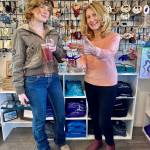 Olga Amaral (right), owner of Diamond Ridge Gallery & Gifts on the Homer Spit, shows Oregon visitor Cameron Kerr a gift item in the store on Wednesday, July 31, 2024, in Homer, Alaska. Photo by Christina Whiting