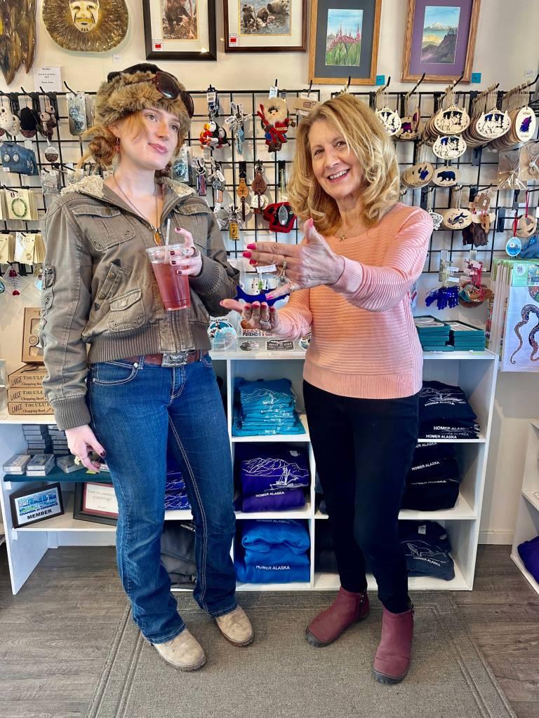 Olga Amaral (right), owner of Diamond Ridge Gallery & Gifts on the Homer Spit, shows Oregon visitor Cameron Kerr a gift item in the store on Wednesday, July 31, 2024, in Homer, Alaska. Photo by Christina Whiting