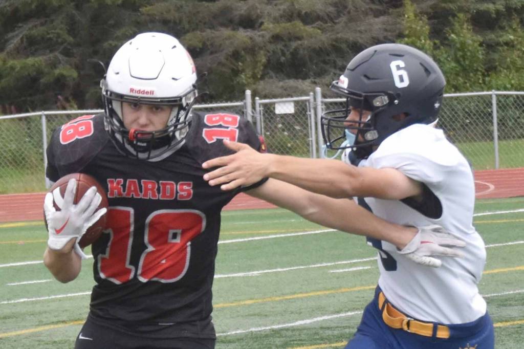 Kenai Central's Aasen Campanella rushes the ball against Homer's Austin Briscoe on Saturday, Aug. 17, 2024, at Ed Hollier Field at Kenai Central High School in Kenai, Alaska. (Photo by Jeff Helminiak/Peninsula Clarion)