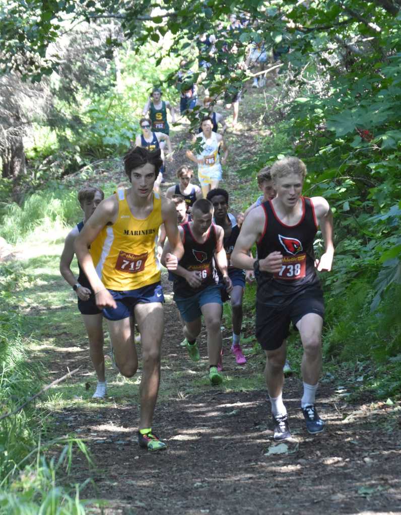 Homers Johannes Bynagle and Kenai Centrals Chase Laker lead the pack up a hil at the junior-senior race Monday, Aug. 19, 2024, at the Peninsula Class Races at Nikiski Middle-High School in Nikiski, Alaska. (Photo by Jeff Helminiak/Peninsula Clarion)