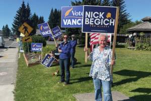 Homer residents hold political signs in support of Alaska House District 6 candidates at WKFL park in Homer on Aug. 20, 2024, in Homer, Alaska. (Emilie Springer/ Homer News)