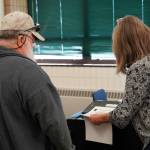 A poll worker helps a voter cast their ballot at the Soldotna Regional Sports Complex in Soldotna, Alaska, during the Alaska Primary Election Day on Tuesday, Aug. 20, 2024. (Jake Dye/Peninsula Clarion)