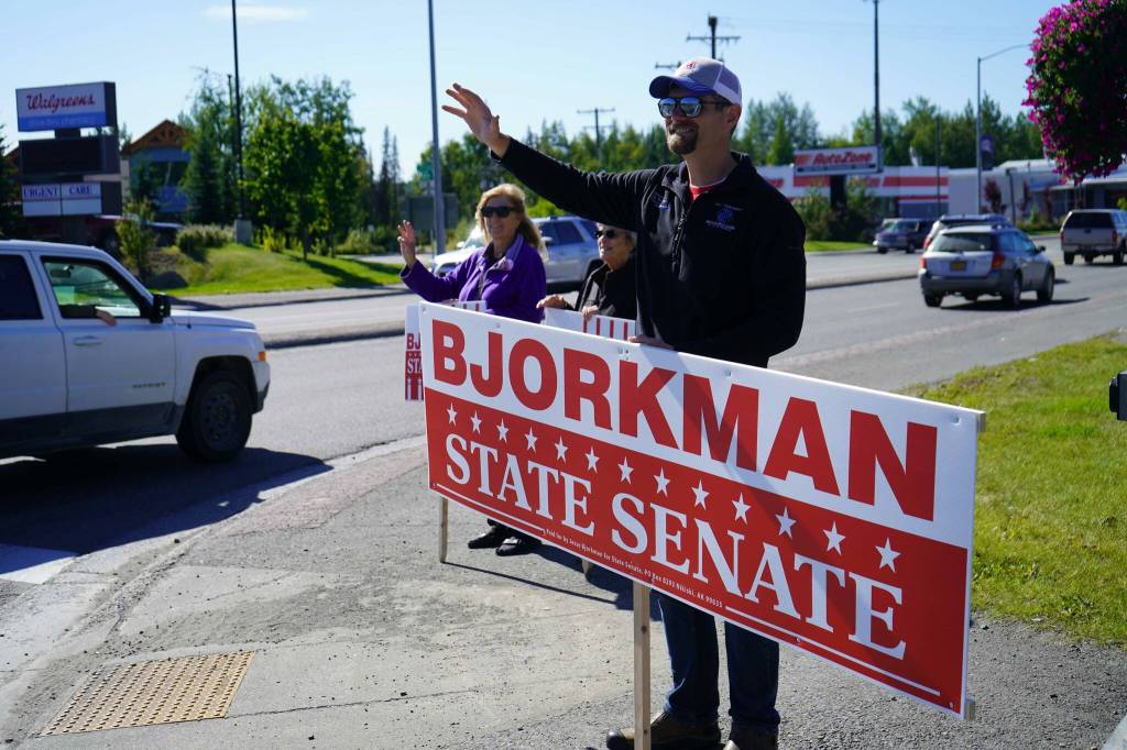 Sen. Jesse Bjorkman, R-Nikiski, and other supporters wave at passersby on the side of the Sterling Highway in Soldotna, Alaska, during the Alaska Primary Election Day on Tuesday, Aug. 20, 2024. (Jake Dye/Peninsula Clarion)