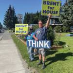 Homer residents hold political signs in support of Alaska House District 6 candidates at the corner of Pioneer Avenue and Lake Street on Aug. 20, 2024, in Homer, Alaska. (Emilie Springer/ Homer News)