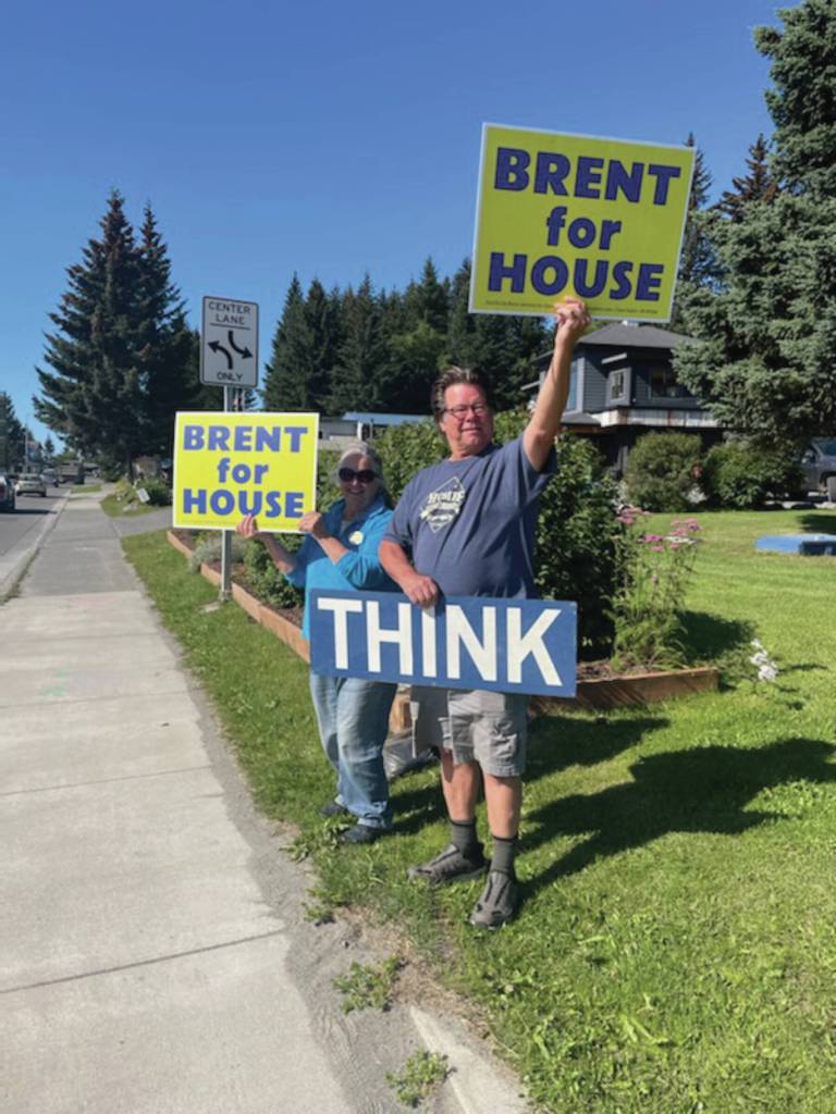 Homer residents hold political signs in support of Alaska House District 6 candidates at the corner of Pioneer Avenue and Lake Street on Aug. 20, 2024, in Homer, Alaska. (Emilie Springer/ Homer News)