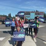 Homer residents hold political signs in support of Alaska House District 6 candidates at the corner of Pioneer Avenue and Lake Street in Homer, Alaska, on Aug. 20, 2024. ( Emilie Springer/ Homer News)