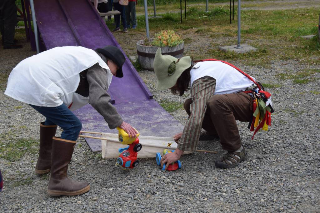 Race medics pick up toppled zucchini cars from the finish line to carry them back to the start during the Zucchini Festival at the Homer Farmers Market on Saturday, Aug. 24, 2024, in Homer, Alaska. (Delcenia Cosman/Homer News)