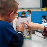 Students sit down to read books on the first day of the school year at Tustumena Elementary School in Kasilof, Alaska, on Wednesday, Aug. 21, 2024. (Jake Dye/Peninsula Clarion)