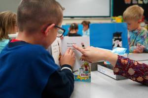 Students sit down to read books on the first day of the school year at Tustumena Elementary School in Kasilof, Alaska, on Wednesday, Aug. 21, 2024. (Jake Dye/Peninsula Clarion)