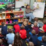 First grade students listen as their teacher reads a book on the first day of the school year at Aurora Borealis Charter School in Kenai, Alaska, on Wednesday, Aug. 21, 2024. (Jake Dye/Peninsula Clarion)