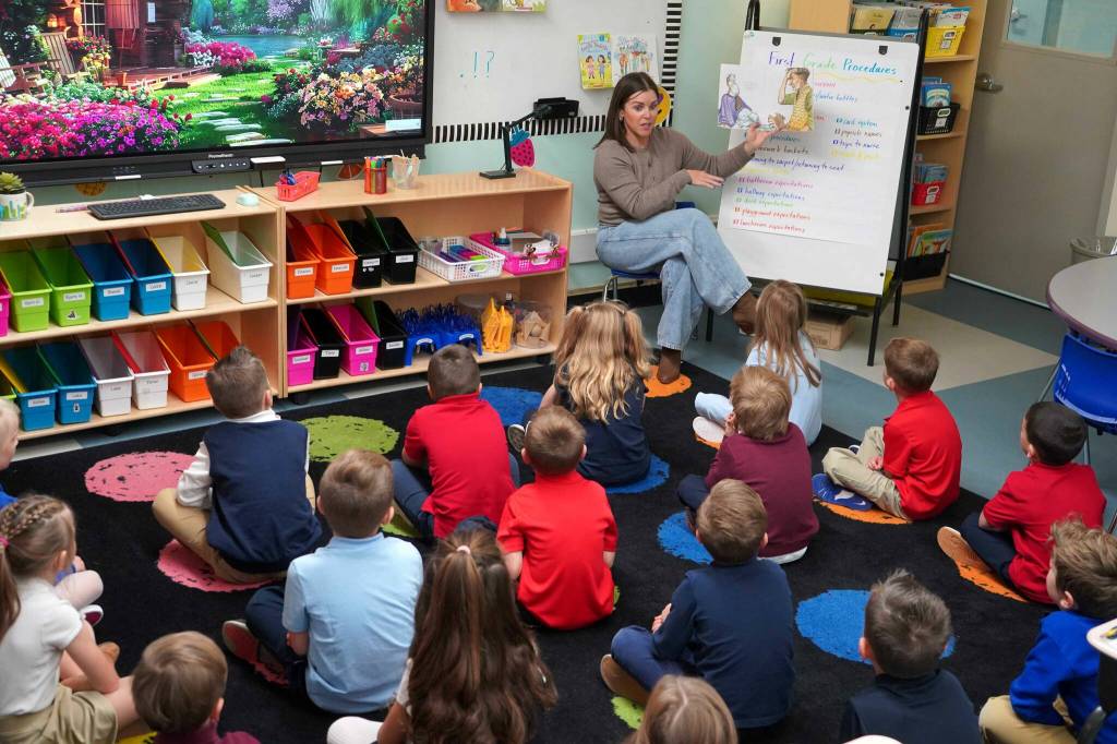 First grade students listen as their teacher reads a book on the first day of the school year at Aurora Borealis Charter School in Kenai, Alaska, on Wednesday, Aug. 21, 2024. (Jake Dye/Peninsula Clarion)