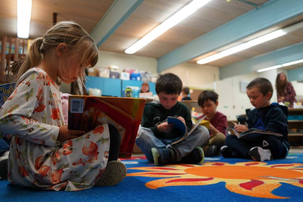 Students sit down to read books on the first day of the school year at Tustumena Elementary School in Kasilof, Alaska, on Wednesday, Aug. 21, 2024. (Jake Dye/Peninsula Clarion)