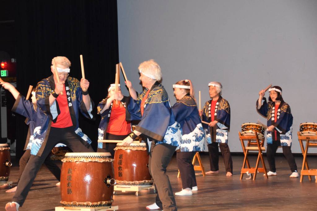 Frank Jeffries (front left) and Jacki Holzman (front right) play together during Tomodachi Daikos first taiko drum performance on Saturday, May 4, 2024 in the Homer High School Mariner Theatre in Homer, Alaska. Pictured in the background are Naoyuki Furuta (left), one of the leaders of Tokyo-based taiko group Chokoma, and TDI founder Sachiko Kono (right). (Delcenia Cosman/Homer News)