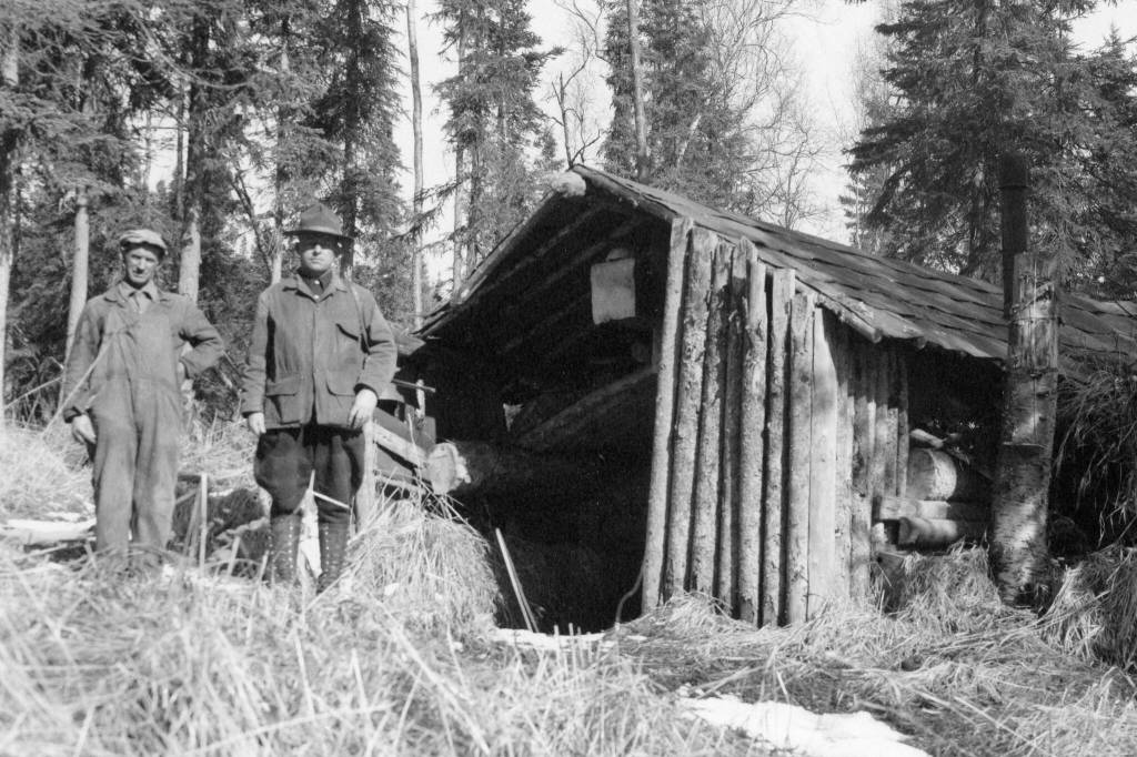 During the brief time (1933-34) that Bob Huttle (right) spent on Tustumena Lake, he documented a tremendous number of structures and described many of the people he met there. One of the men he traveled with frequently was John Frenchy Cannon (left), seen here at the Upper Bear Creek Cabin. (Photo courtesy of the Robert Huttle Collection)