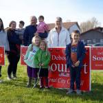 Deborah Sounart, alongside family and supporters, waves signs alongside the Kenai Spur Highway in Kenai, Alaska, on Tuesday, Oct. 1, 2024. (Jake Dye/Peninsula Clarion)