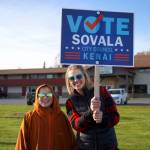 Supporters of Sovala Kisena wave signs at the side of the Kenai Spur Highway in Kenai, Alaska, on Tuesday, Oct. 1, 2024. (Jake Dye/Peninsula Clarion)