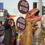 Board of Education candidate Sarah Douthit and her supporters wave signs at the side of the Kenai Spur Highway in Kenai, Alaska, on Tuesday, Oct. 1, 2024. (Jake Dye/Peninsula Clarion)