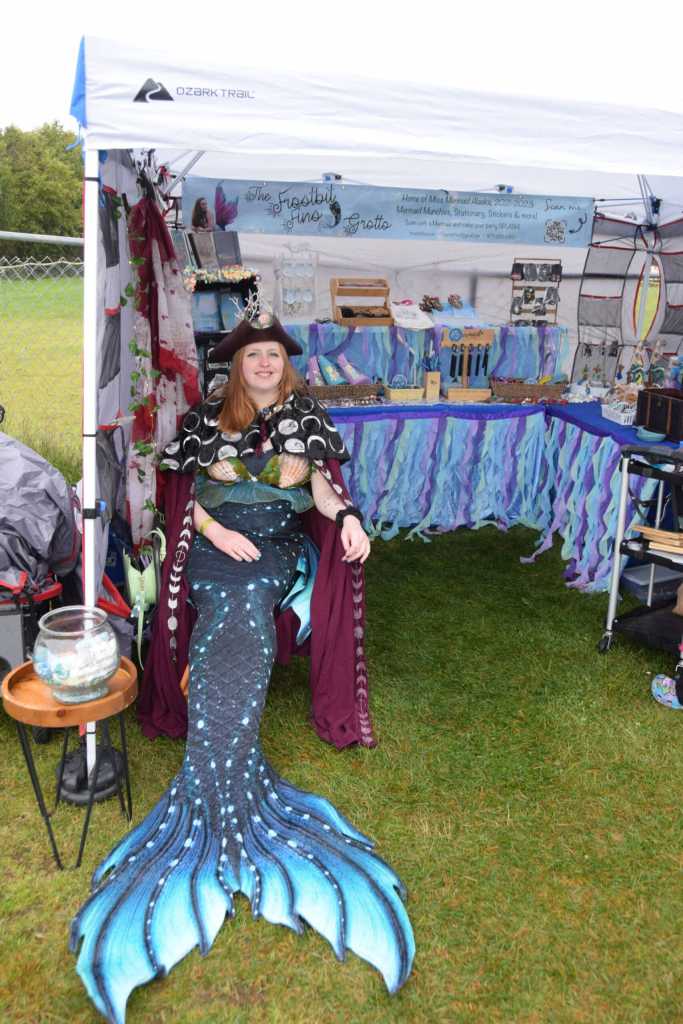 Mermaid performance artist JessiAnna McDonald mans her vendors tent as her alter-ego, AnneMeridia, at Ye Olde Harvest Festival at Karen Hornaday Park on Saturday, Oct. 5, 2024, in Homer, Alaska. (Delcenia Cosman/Homer News)
