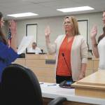 Administrative Secretary Nikkol Sipes administers oaths of office to Kenai Peninsula Borough School District Board of Education members Kelley Cizek and Sarah Douthit on Monday, Oct. 14, 2024. Cizek was reelected to represent Sterling and Funny River, Douthit was elected to represent Kenai during the Oct. 1 municipal election. (Jake Dye/Peninsula Clarion)