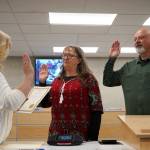 Borough Clerk Michele Turner administers oaths of office to Cindy Ecklund and James Baisden during a meeting of the Kenai Peninsula Borough Assembly in Soldotna, Alaska, on Tuesday, Oct. 8, 2024. Ecklund was reelected and Baisden was elected to the assembly during the Oct. 1 election. (Jake Dye/Peninsula Clarion)