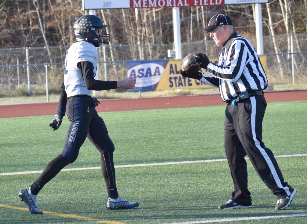 Homers CJ Burns hands the ball to the official after scoring the first touchdown of the game Saturday, Oct. 19, 2024, in the Division III First National Bowl at Veterans Memorial Field at Wasilla High School in Wasilla, Alaska. (Photo by Jeff Helminiak/Peninsula Clarion)