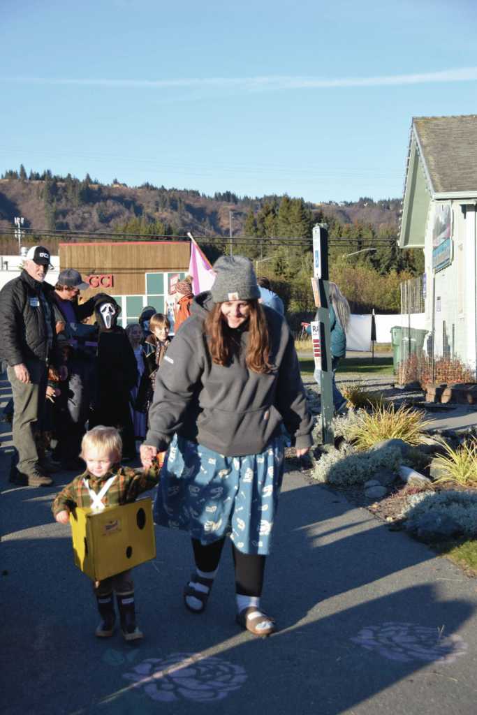 Jaydyn Fangsrud (right) leads her son, Roaryck, costumed as a wedge of Tillamook cheese, down the runway for the Kids Costume Contest during the third annual Fall Fest on Saturday, Oct. 26<ins>, 2024,</ins> at the Homer Chamber of Commerce and Visitor Center<ins> in Homer, Alaska</ins>. (Delcenia Cosman/Homer News)