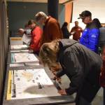 Community members examine illustrations of the three proposed growth plans created by the comprehensive plan rewrite project team during a community work session on Tuesday, Oct. 22, 2024, at the Alaska Maritime National Wildlife Refuge Visitor Center in Homer, Alaska. (Delcenia Cosman/Homer News)