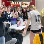 Soldotna's Cassidy Kruse hits Soldotna head coach Luke Baumer with a pie as part of the Killing Cancer on the Kenai event on Friday, Nov. 1, 2024, at Kenai Central High School in Kenai, Alaska. (Photo by Jeff Helminiak/Peninsula Clarion)