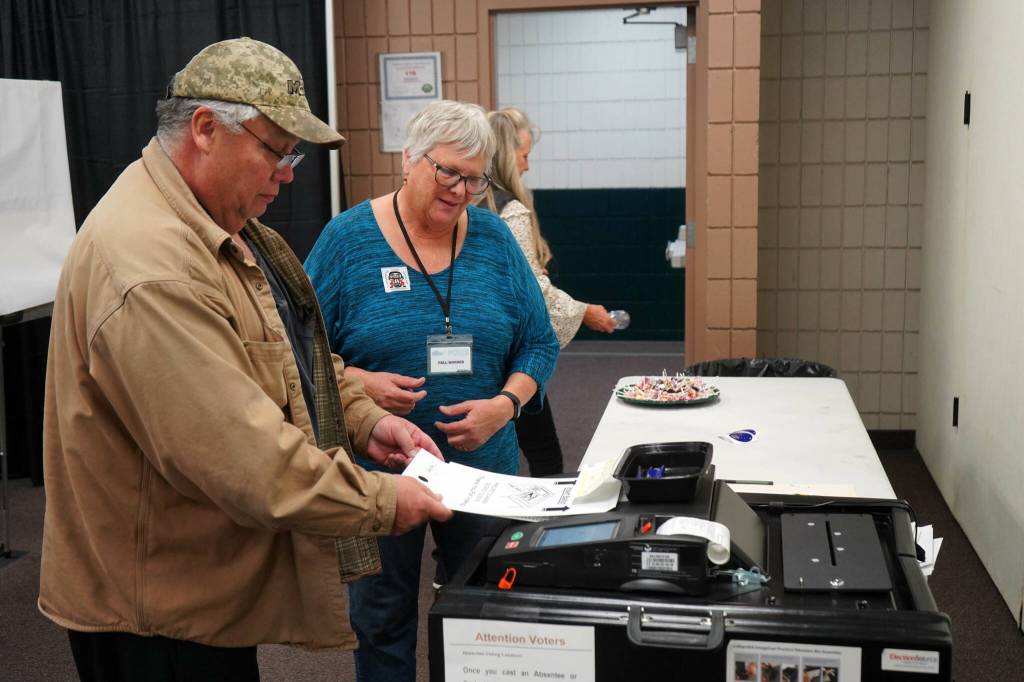 Poll worker Carol Louthan helps voters submit ballots at the Soldotna Regional Sports Complex in Soldotna, Alaska, on Tuesday, Nov. 5, 2024. (Jake Dye/Peninsula Clarion)