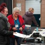 Poll worker Carol Louthan helps voters submit ballots at the Soldotna Regional Sports Complex in Soldotna, Alaska, on Tuesday, Nov. 5, 2024. (Jake Dye/Peninsula Clarion)