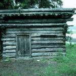 Photo by Clark Fair, 1985
The log shed at Blakes Place on the north shore on Tustumena Lake, near the outlet of Indian Creek. Kerri Dolph holed up here for several days after the death of her husband John.