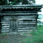 The log shed at Blakes Place on the north shore on Tustumena Lake, near the outlet of Indian Creek. Kerri Dolph holed up here for several days after the death of her husband John. (Photo by Clark Fair, 1985)