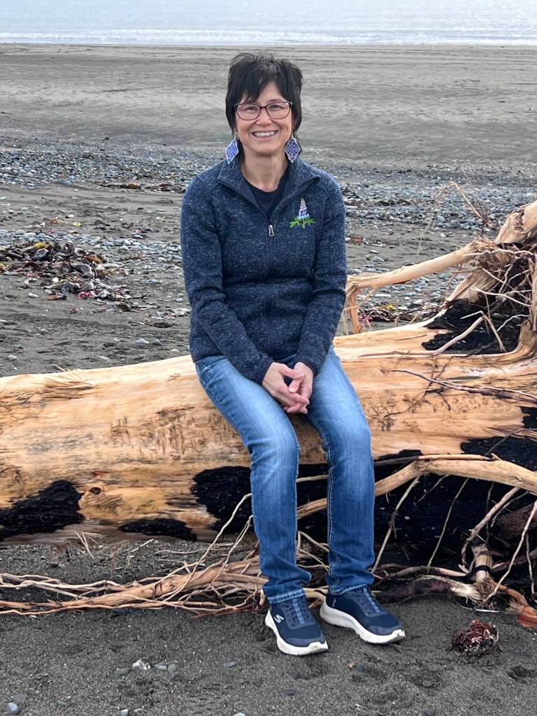 Artist Michelle Anderson, wearing a pair of her beaded earrings, visits the beach at Mariner Park in November 2024 to collect items for her baskets. Photo provided by Michelle Anderson