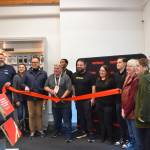 General manager John Fromm (center), Victra Homer employees, Homer Chamber of Commerce staff and board members, and City of Homer staff attend a ribbon cutting ceremony during Victras grand opening on Thursday, Nov. 21, 2024, in Homer, Alaska. (Delcenia Cosman/Homer News)