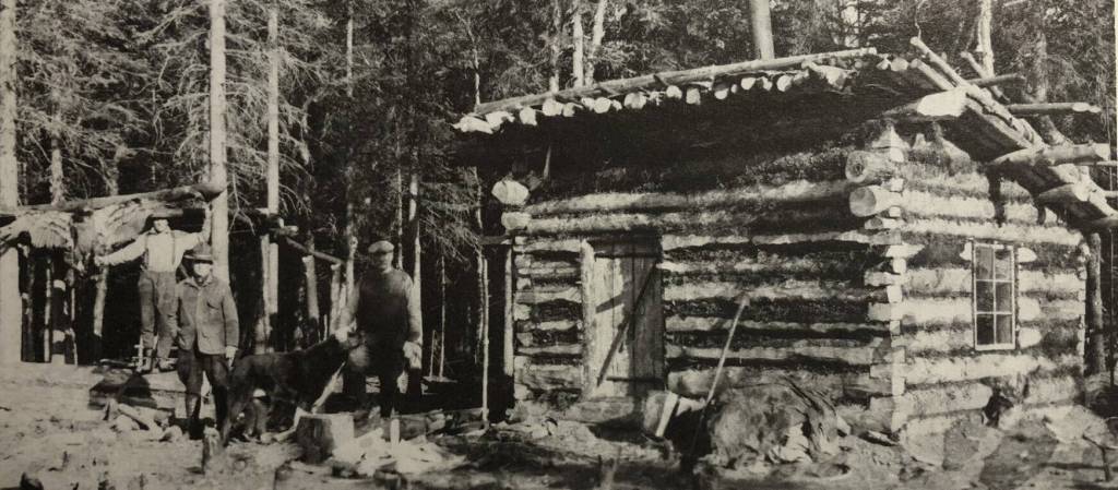 6DRobert Huttle (center) stands between an unidentified man (next to the dead eagle) and Andrew Berg, who probably helped his brother, Emil Berg, to build this log shed on Emils property just east of Indian Creek on Tustumena Lake. Huttle spent much of 1933-34 on the lake and documented many of its cabins and residents. It was in this shed, more than 40 years later, that Kerri Dolph sat, awaiting rescue after the death of her husband John. (Photo courtesy of the Robert Huttle Collection)
