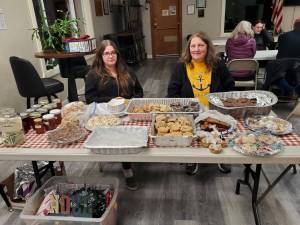 Laurie Rudy (right), board treasurer for the Anchor Point Food Pantry, and Rebecca Rudy (left) host the first night of a two-day bake sale fundraiser for the Anchor Point Food Pantry held at the Virl Pa Haga VFW Post 10221 on Friday, Dec. 20, 2024, in Anchor Point, Alaska. Items for sale during the fundraiser were made and donated by members of the community. (Delcenia Cosman/Homer News)