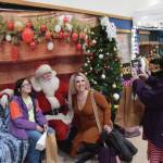 Parents and kids pose for photos with Santa at the Procrastinators Fair on Saturday, Dec. 21<ins>, 2024,</ins> at Christian Community Church in Homer<ins>, Alaska</ins>. (Delcenia Cosman/Homer News)