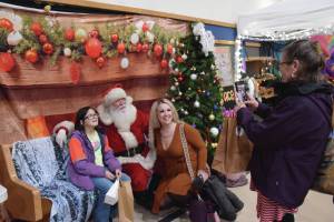 Parents and kids pose for photos with Santa at the Procrastinators Fair on Saturday, Dec. 21<ins>, 2024,</ins> at Christian Community Church in Homer<ins>, Alaska</ins>. (Delcenia Cosman/Homer News)