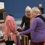 Bonita Banks (rear) talks with a patron at her booth, sit.breathe.weave handwovens, at the Procrastinators Fair on Saturday, Dec. 21<ins>, 2024,</ins> at Christian Community Church in Homer<ins>, Alaska</ins>. (Delcenia Cosman/Homer News)