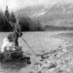 Keith McCullagh is photographed poling a raft down the Kenai River in 1911 during a forest survey. (U.S. Forestry Department photo by John Jack Brown)