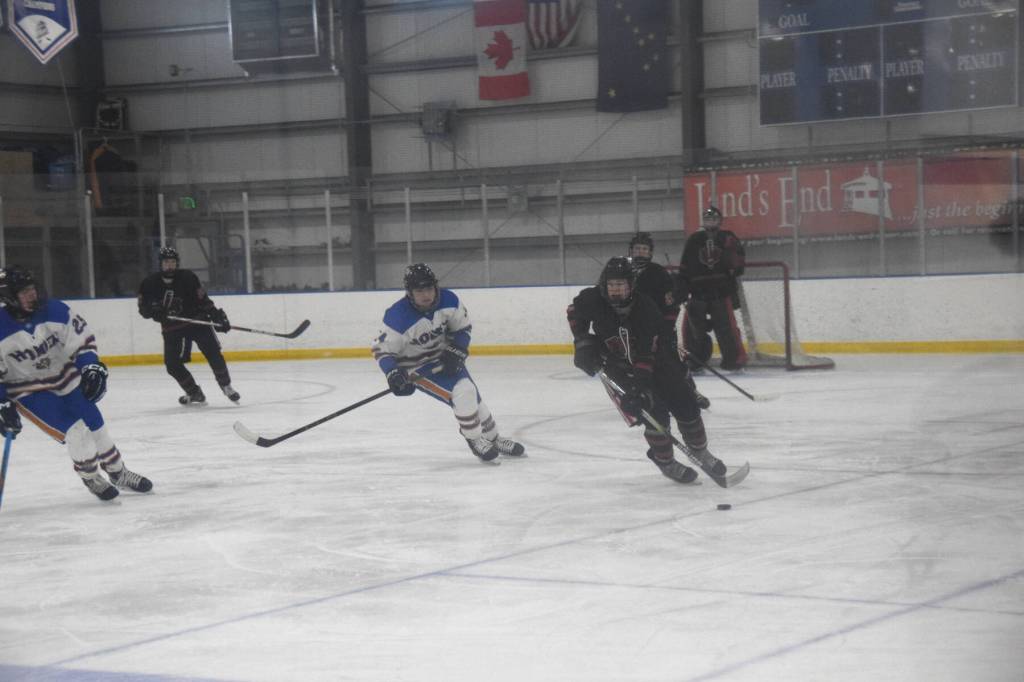 Berend Pearson (14) pursues a Juneau player during the varsity hockey game on Saturday, Jan. 11, 2025, at Kevin Bell Arena in Homer, Alaska. (Delcenia Cosman/Homer News)