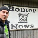 Tim Hatfield takes a selfie with the Homer News sign, displayed on the side of the papers old office on Landings Street, on Nov. 17, 2024, in Homer, Alaska. Photo provided by Tim Hatfield