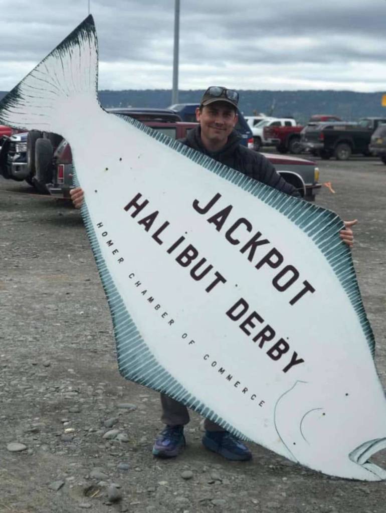 Tim Hatfield poses with the Homer Halibut Derby sign in this undated photo on the Homer Spit in Homer, Alaska. Photo provided by Tim Hatfield