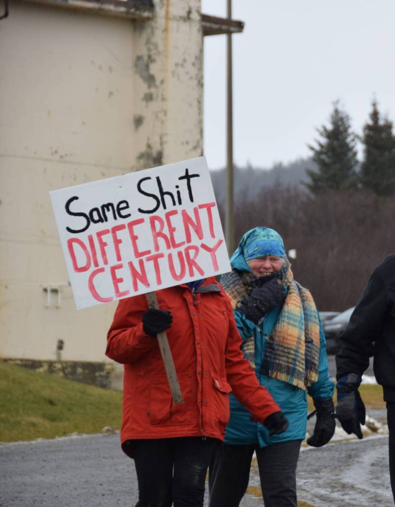 A woman carries a sign that says Same Shit, Different Century during the Homer Womens March on Saturday, Jan. 18, 2025, in Homer, Alaska. (Delcenia Cosman/Homer News)